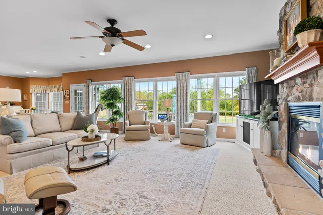 a kitchen with stainless steel appliances granite countertop a stove top oven a sink a dining table and chairs with wooden floor