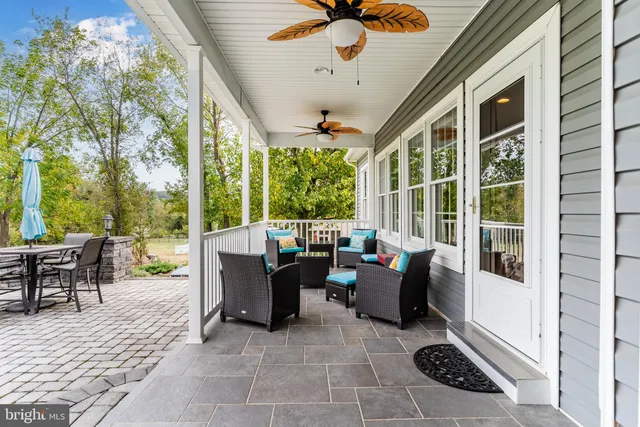 a living room with patio furniture and garden view