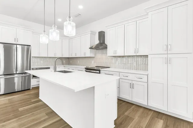a kitchen with kitchen island white cabinets and stainless steel appliances