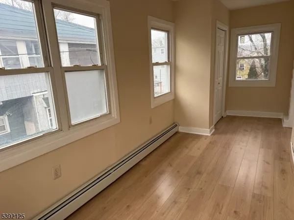 a view of a room with wooden floor and windows