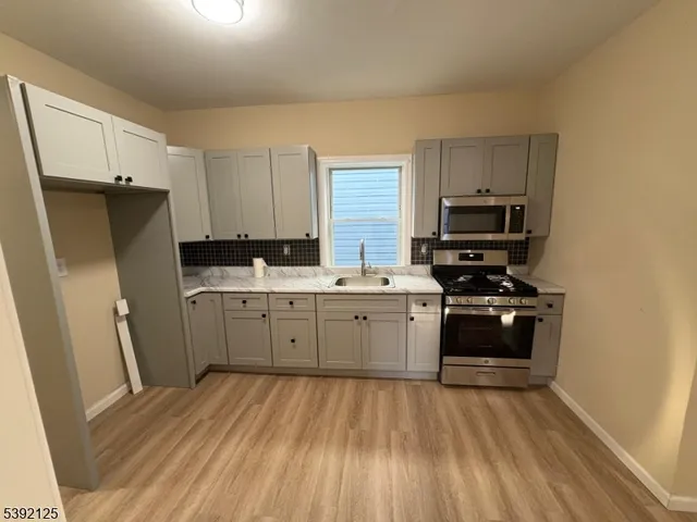a kitchen with a sink a stove a refrigerator and cabinets