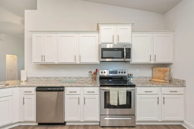a kitchen with white cabinets and appliances