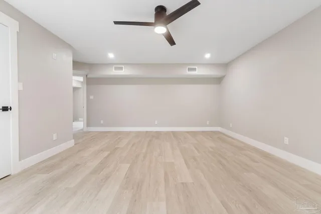 an empty room with a empty space and a ceiling fan