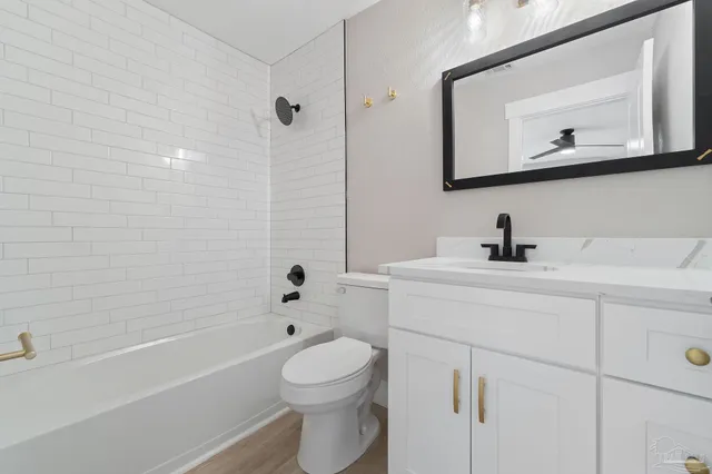 a bathroom with a toilet a sink a mirror and bathtub