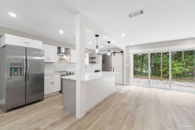 a large white kitchen with stainless steel appliances