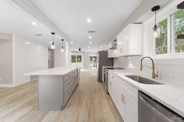 a large kitchen with kitchen island a sink a counter space and stainless steel appliances