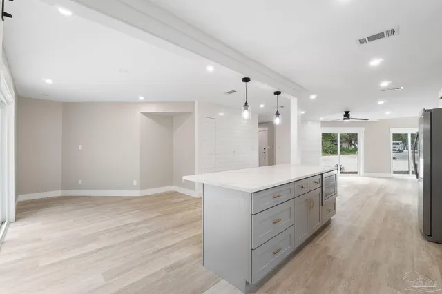 a large kitchen with a lot of counter space and wooden floor