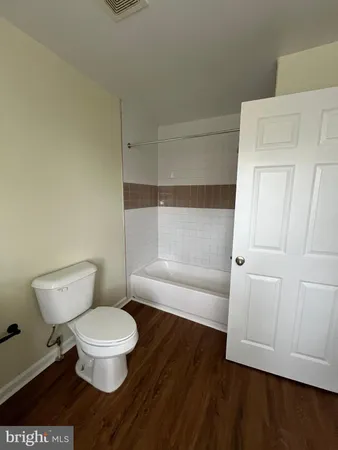 a white toilet sitting next to a bathroom sink and a tub