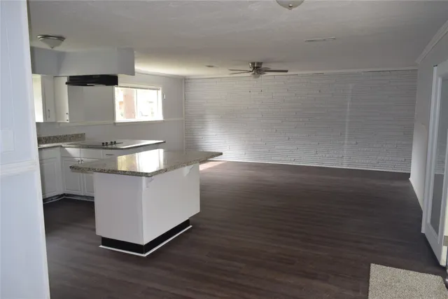 a room with a sink cabinets and wooden floor
