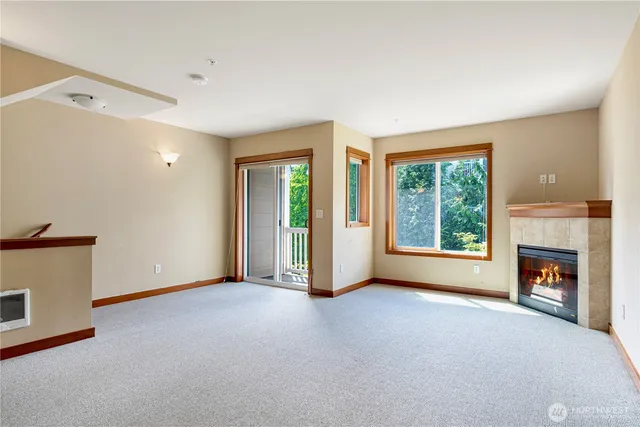 a view of an empty room with a fireplace and a window