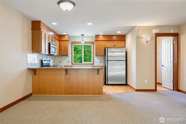 a view of kitchen with stainless steel appliances granite countertop a refrigerator and a sink