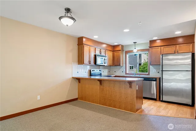 a kitchen with stainless steel appliances granite countertop a refrigerator a sink and a stove