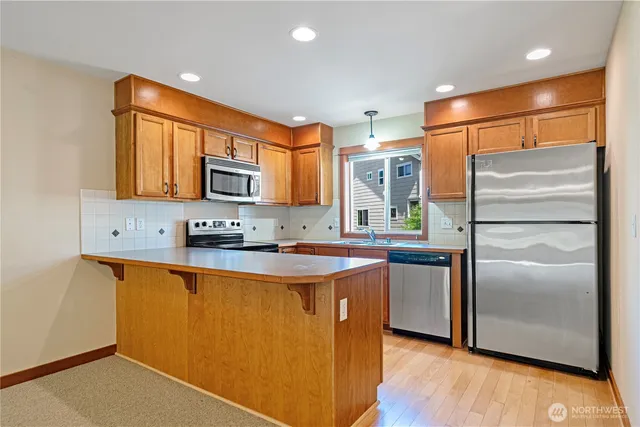 a kitchen with stainless steel appliances granite countertop a refrigerator and a stove top oven