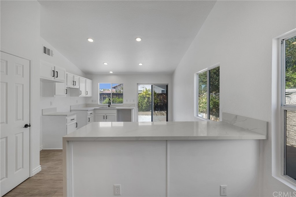 175 Paperbirch Circle Corona, CA 92881 - Photo 8 of 33 a view of kitchen with white cabinets and outdoor space