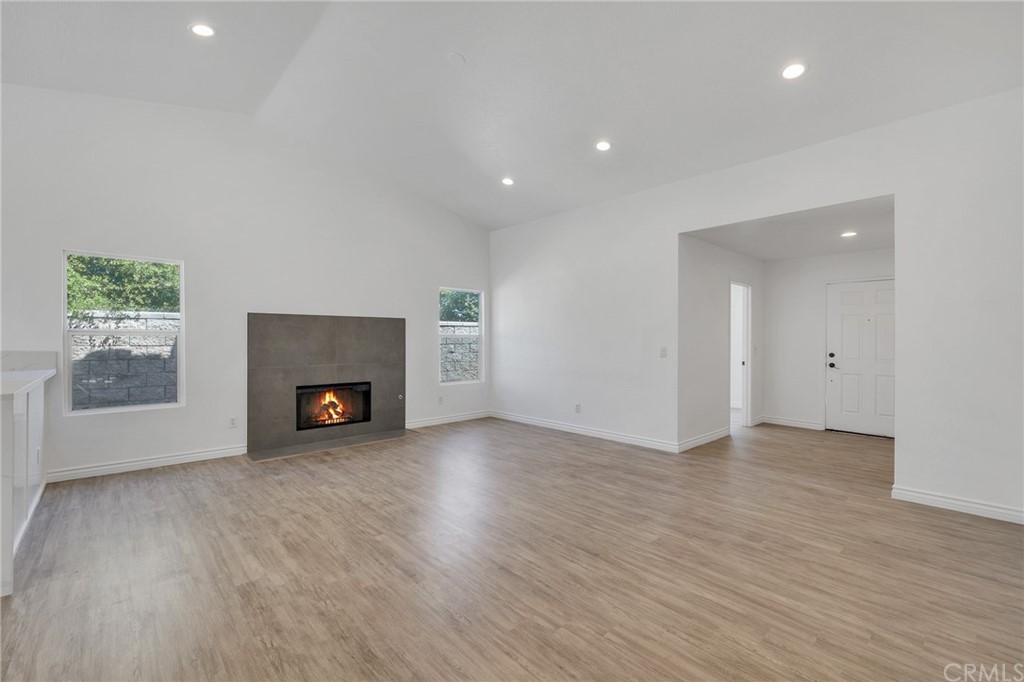 175 Paperbirch Circle Corona, CA 92881 - Photo 9 of 33 an empty room with wooden floor a fireplace and windows