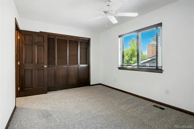 a view of a big room with windows and chandelier fan