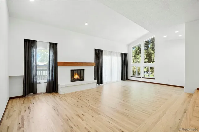 a view of an empty room with window and fire place