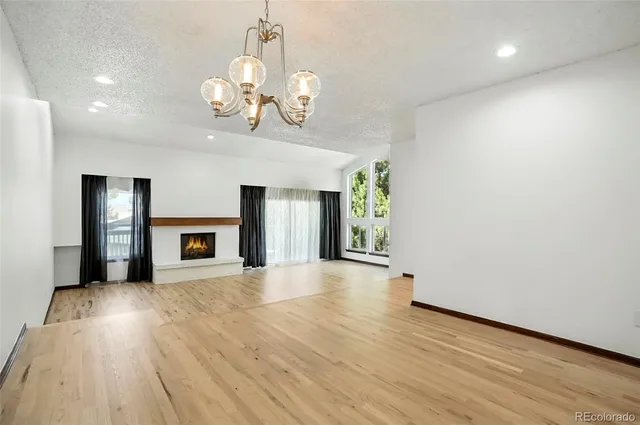 a kitchen with stainless steel appliances kitchen island granite countertop a refrigerator a sink dishwasher a stove and white cabinets with wooden floor