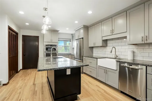 a kitchen with stainless steel appliances granite countertop a sink stove and refrigerator