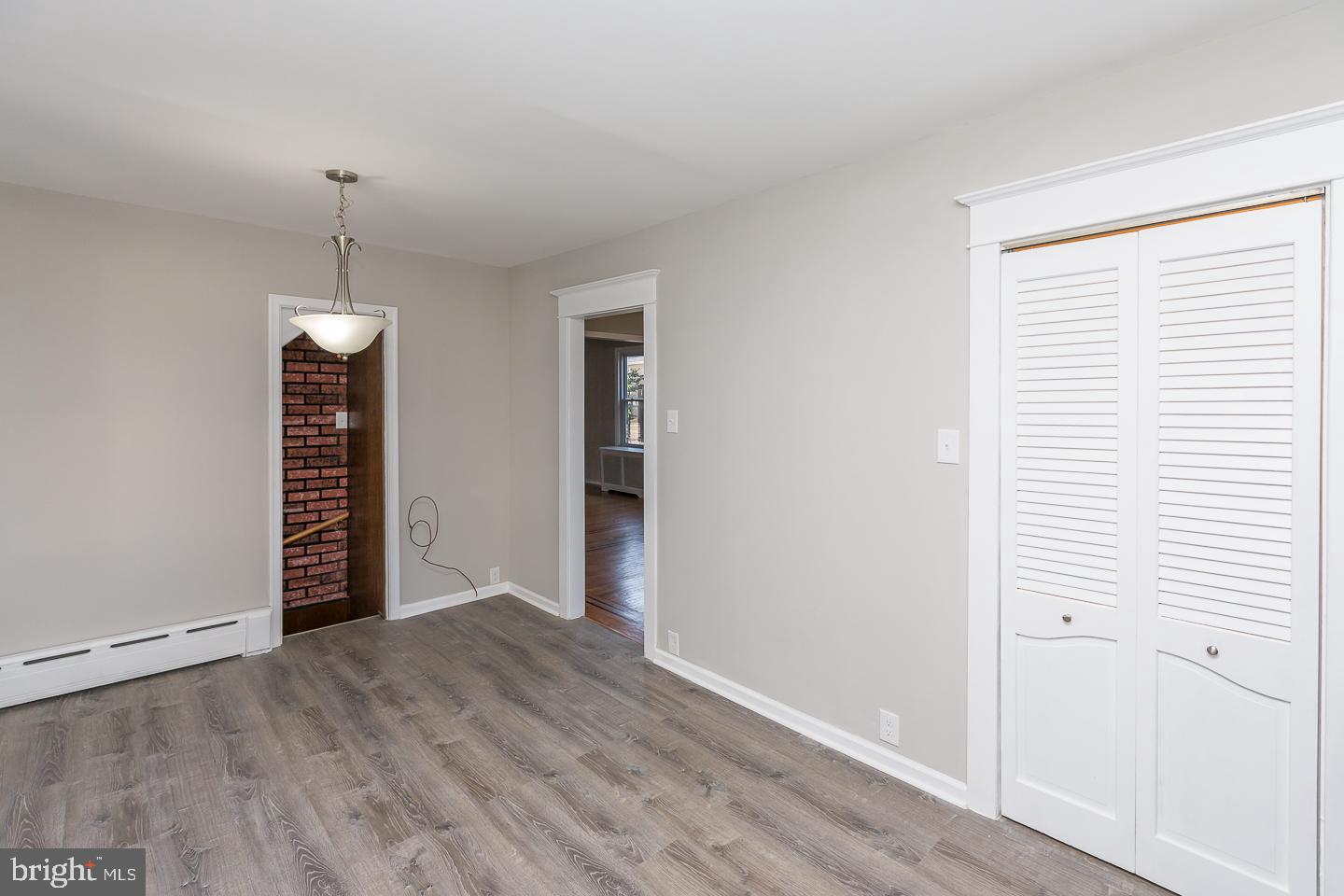 136 Shelbourne Road Havertown, PA 19083 - Photo 23 of 48 an empty room with wooden floor cabinet and a hallway