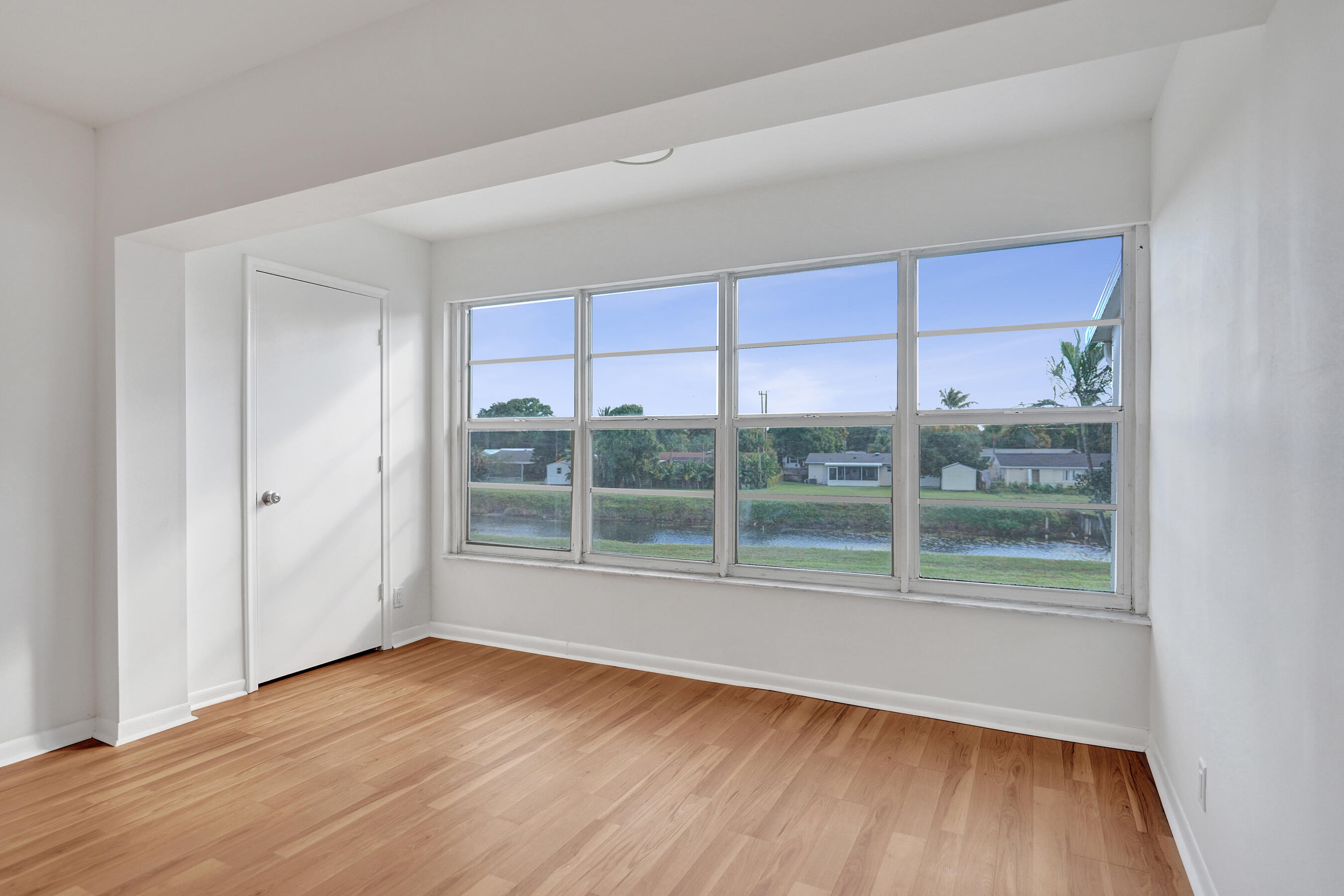 1130 Mahogany Way, Unit 203 Delray Beach, FL 33445 - Photo 14 of 34 an empty room with wooden floor and windows