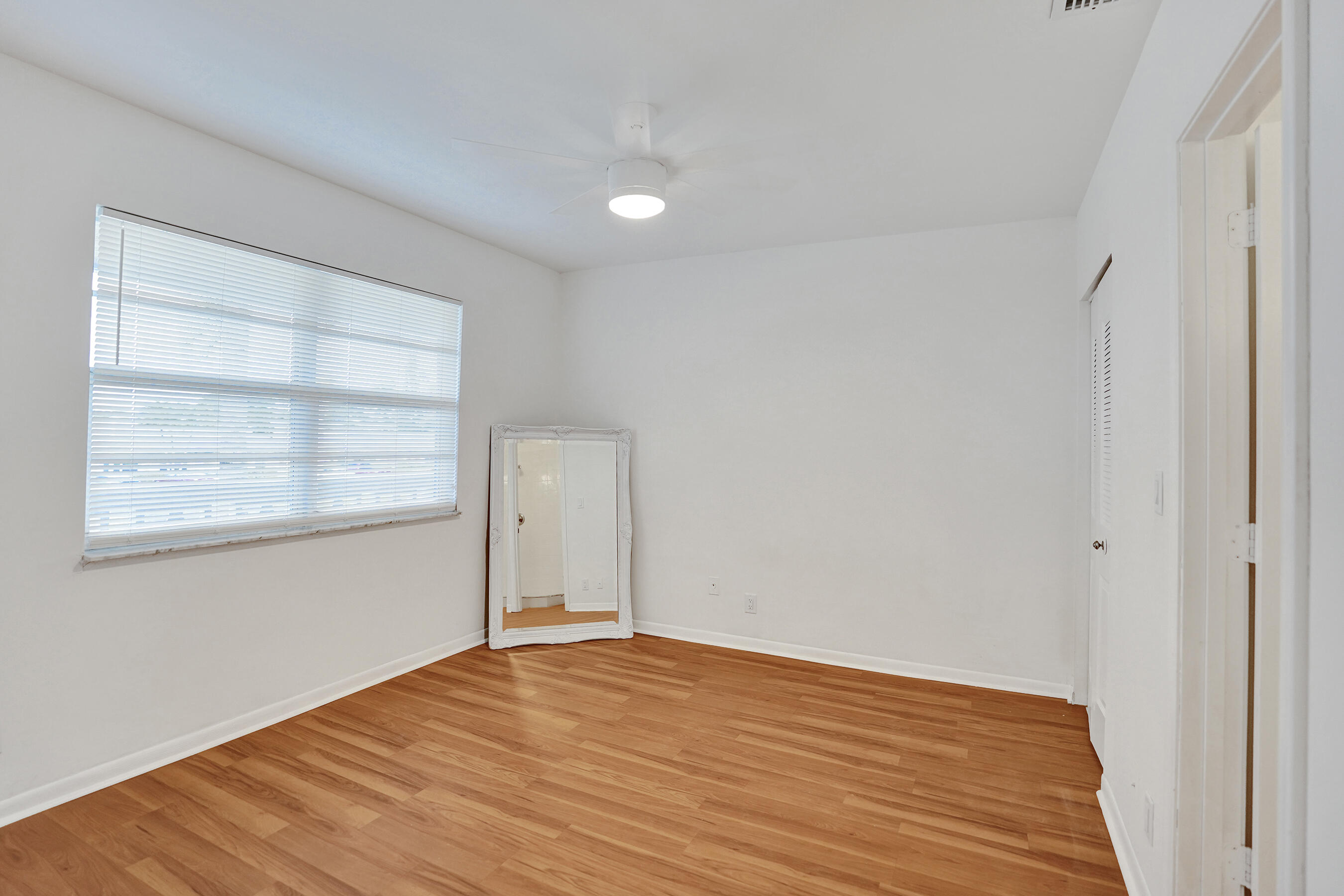 1130 Mahogany Way, Unit 203 Delray Beach, FL 33445 - Photo 20 of 34 a view of empty room with wooden floor and fan