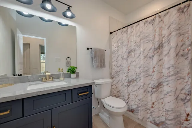 a bathroom with a granite countertop sink toilet and a mirror