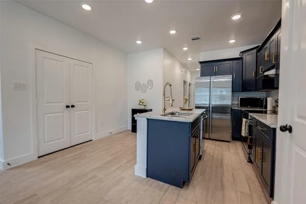 a kitchen with stainless steel appliances granite countertop a sink stove and refrigerator