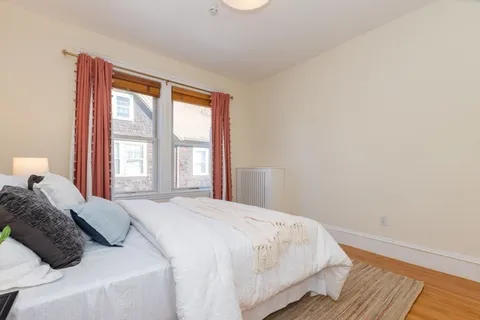 a bedroom with a bed and a large window