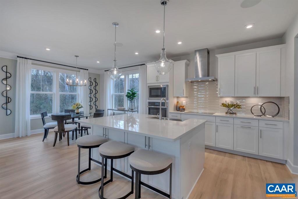 2837 Rambling Brook Lane Crozet, VA 22932 - Photo 6 of 24 a large kitchen with kitchen island a dining table and chairs