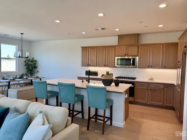 a kitchen with granite countertop a table chairs microwave and cabinets