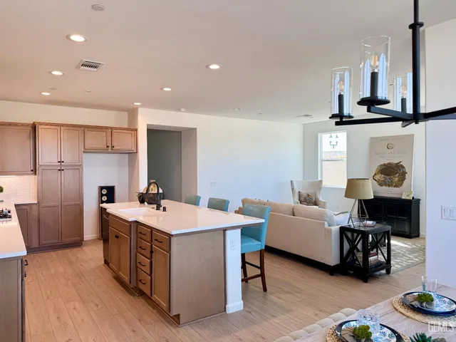 a view of kitchen with sink stainless steel appliances and living room view