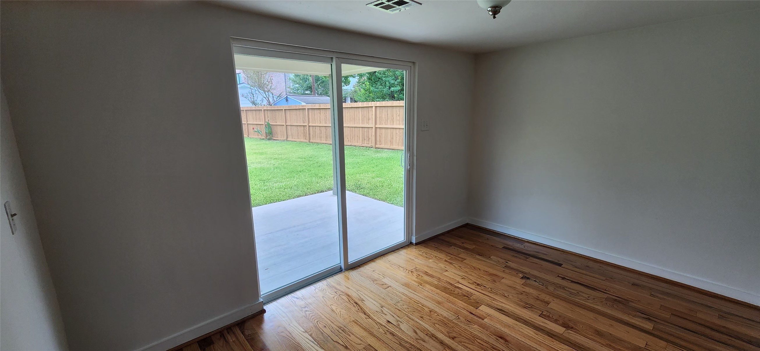 5501 Huisache Street Houston, TX 77081 - Photo 13 of 15 a view of an empty room with wooden floor and a window