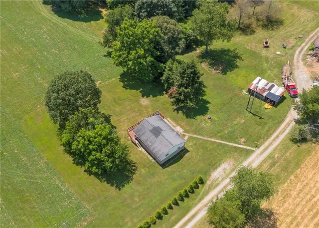 a view of a house with a big yard and large trees