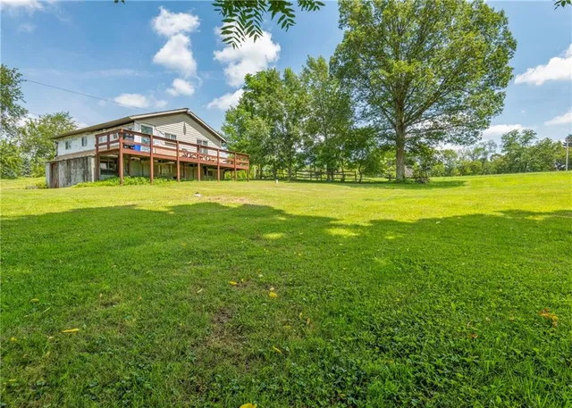 a view of a big house with a big yard and large trees