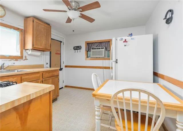 a kitchen with a refrigerator a sink a stove a window and cabinets