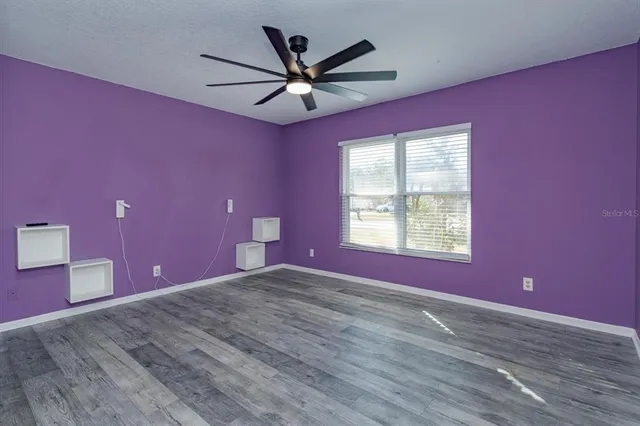 a view of a livingroom with a ceiling fan and window