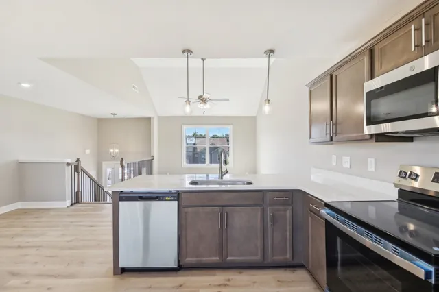 a kitchen with stainless steel appliances granite countertop a sink a stove and a wooden floors
