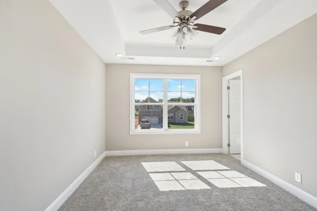 an empty room with windows and fan