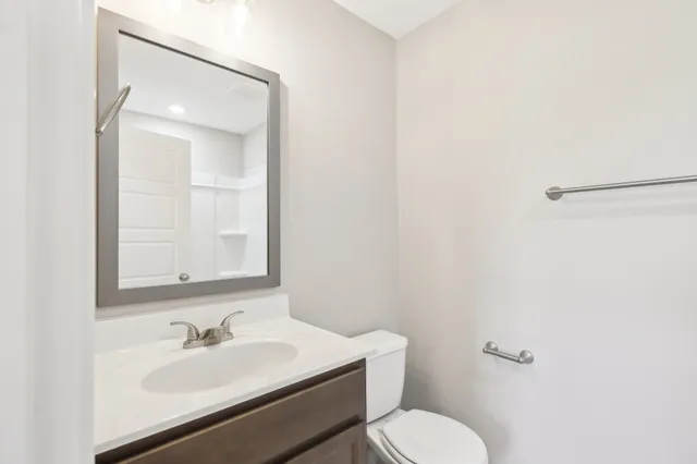 a bathroom with a granite countertop sink mirror and a toilet