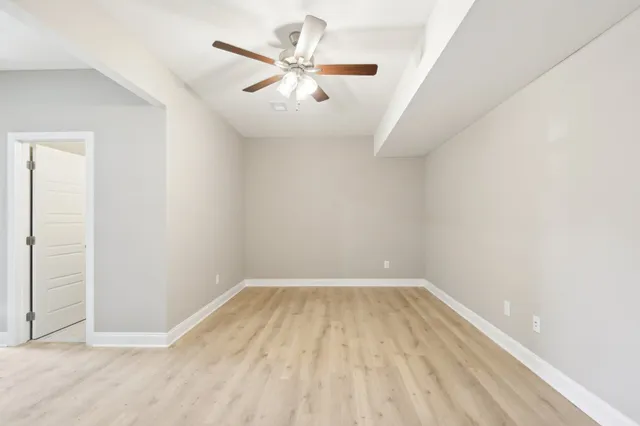 an empty room with a ceiling fan and carpet