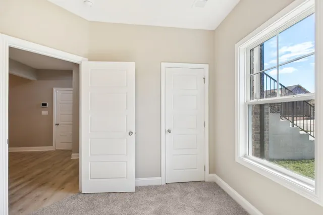 an empty room with windows and closet