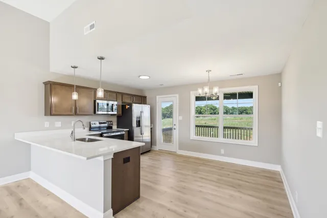 a kitchen with kitchen island a sink stove and wooden floor
