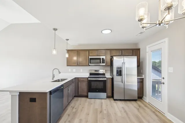 a kitchen with stainless steel appliances granite countertop a refrigerator a sink a stove a microwave and island