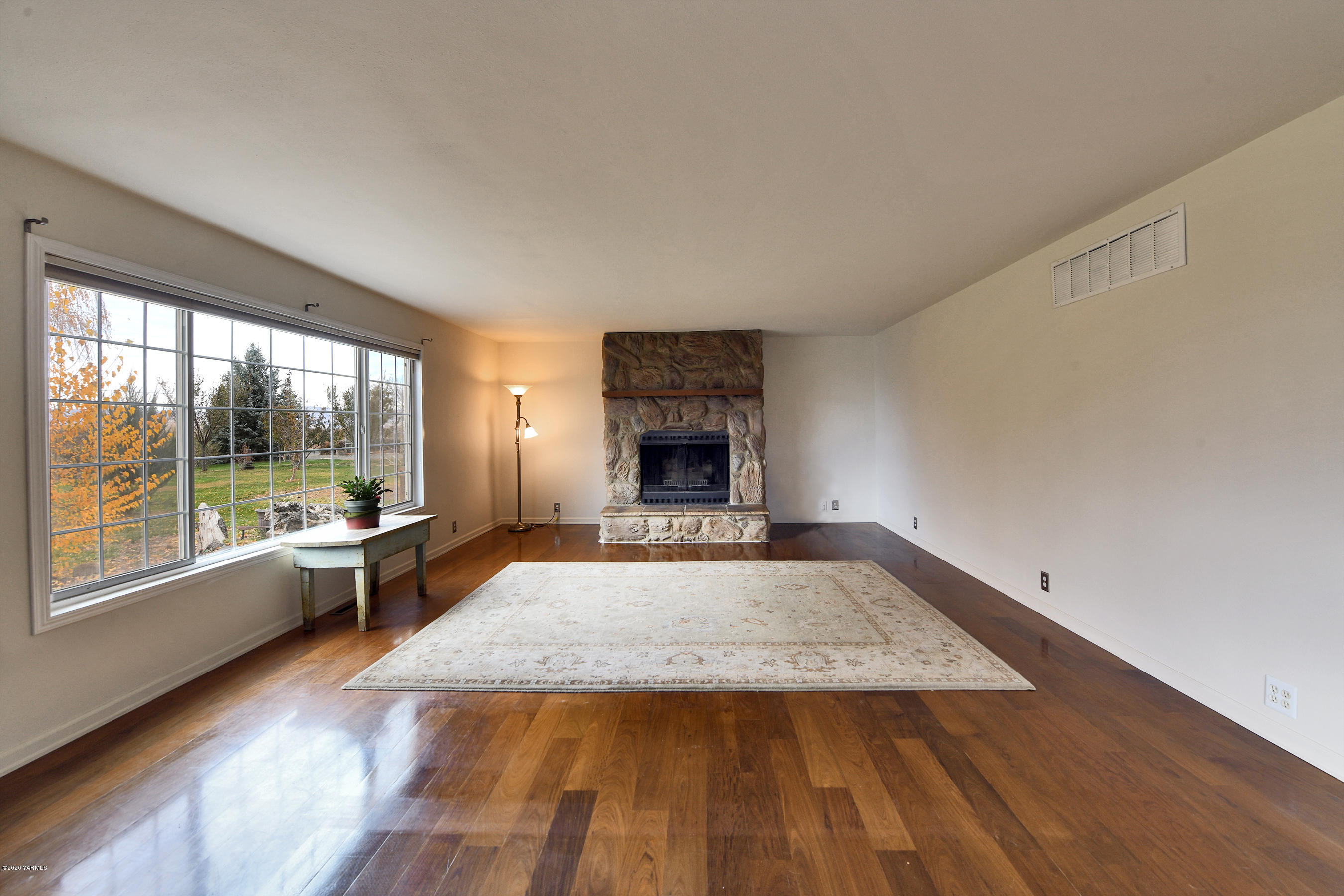 951 Batali Road Harrah, WA 98933 - Photo 4 of 22 an empty room with fireplace wooden floor and windows