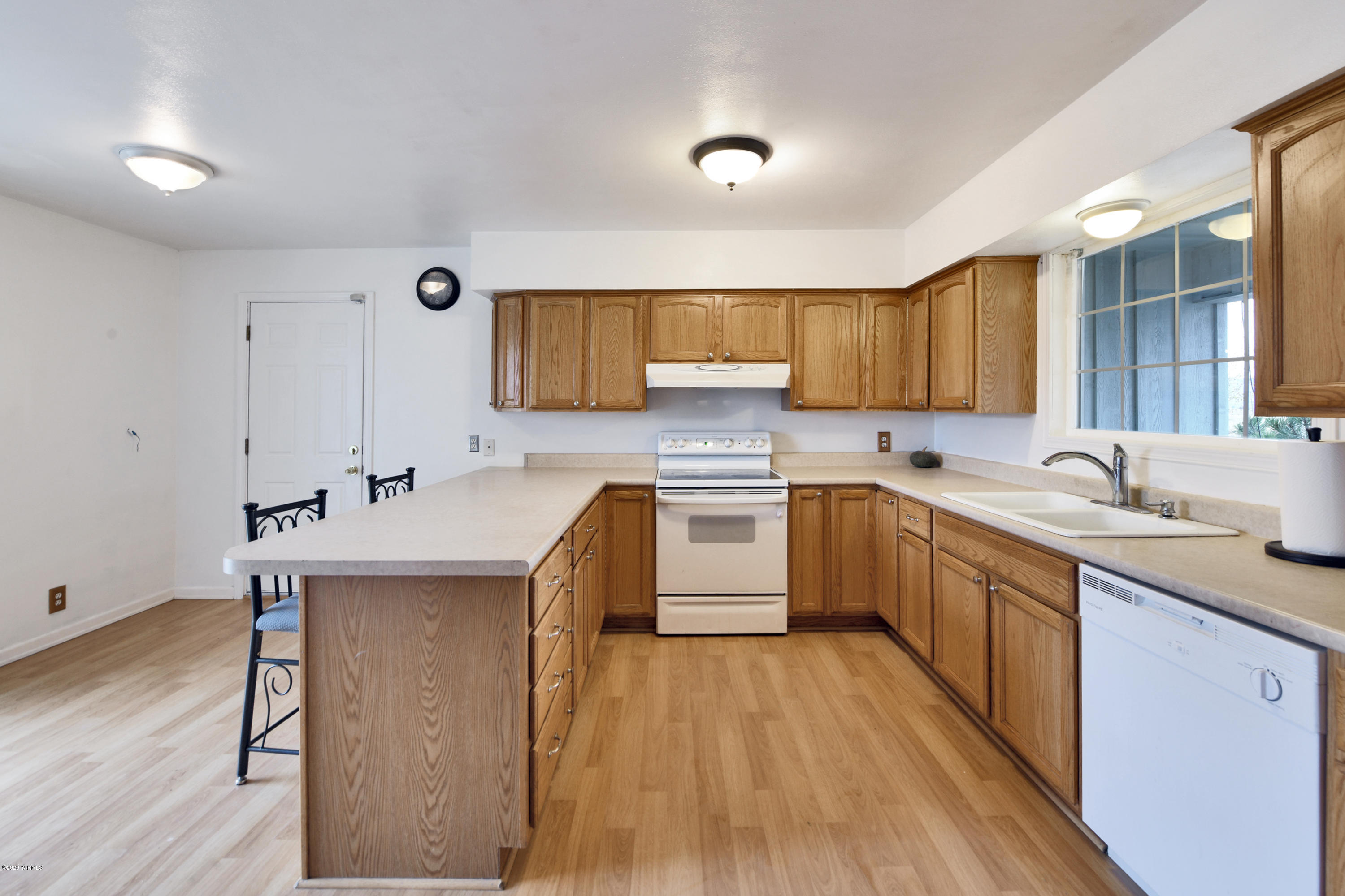 951 Batali Road Harrah, WA 98933 - Photo 10 of 22 a kitchen with a sink cabinets wooden floor and stainless steel appliances
