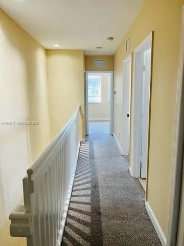 a view of a hallway with wooden floor and entryway