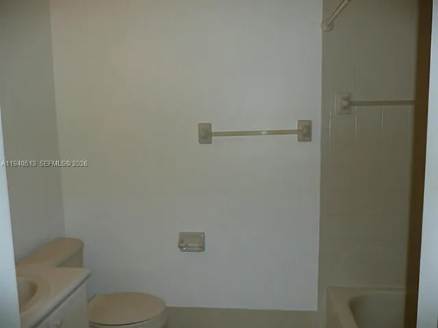 a white toilet sitting next to a shower