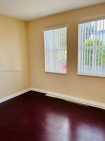a view of a room with wooden floor and a window