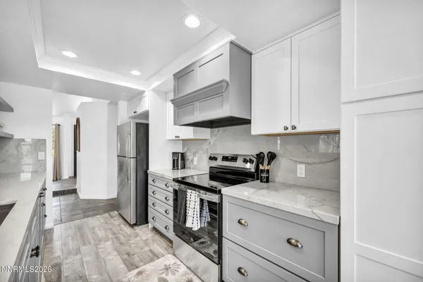 a kitchen with stainless steel appliances granite countertop a stove a refrigerator and a white cabinets